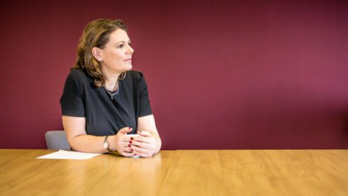 woman at desk holding a coffee mug