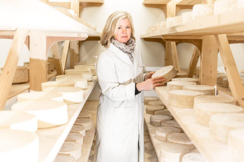 woman in a cheese factory holding cheese