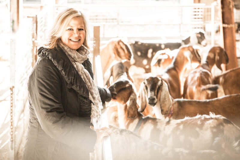 woman on a farm with goats