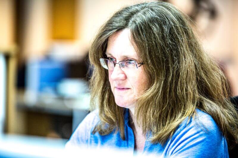 woman in glasses looking at a computer screen