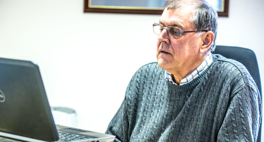 man sat at desk looking at laptop swindells east sussex accounting and tax