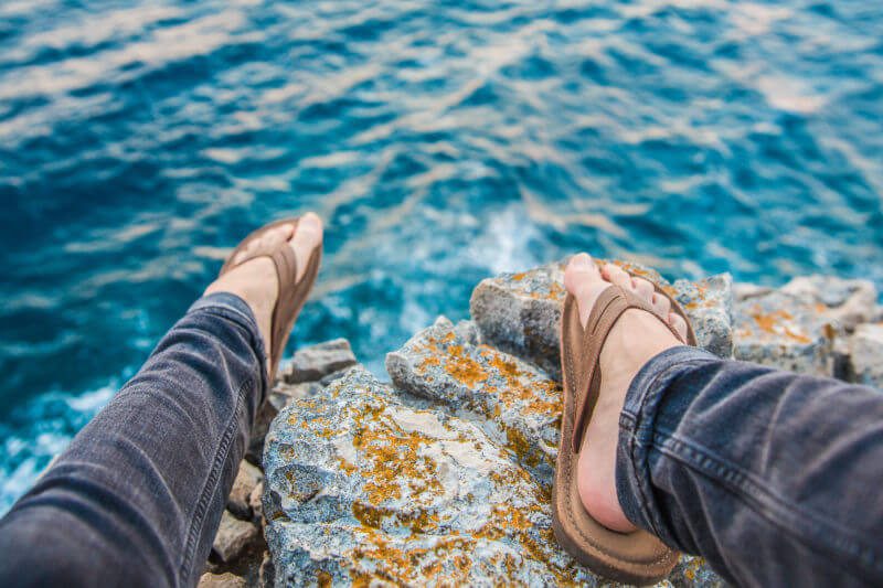 Tax when working abroad flip flops and feet on cliff