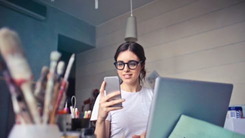 Woman with phone at desk Swindells East Sussex Accountants