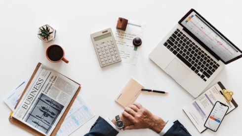 Man sat at desk surrounded by laptop and paper swindells east sussex accounting
