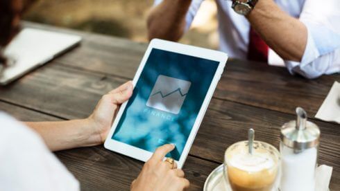 Man on ipad at table with drink swindells accounting and tax sussex